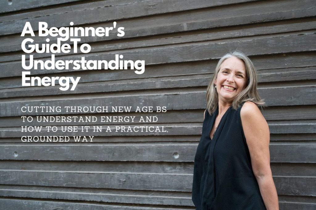 Picture of Lisa Higgins standing against a wooden wall, with the words, A Beginner’s Guide To Understanding Energy, cutting through new age BS to understand energy and how to use it in a practical grounded way